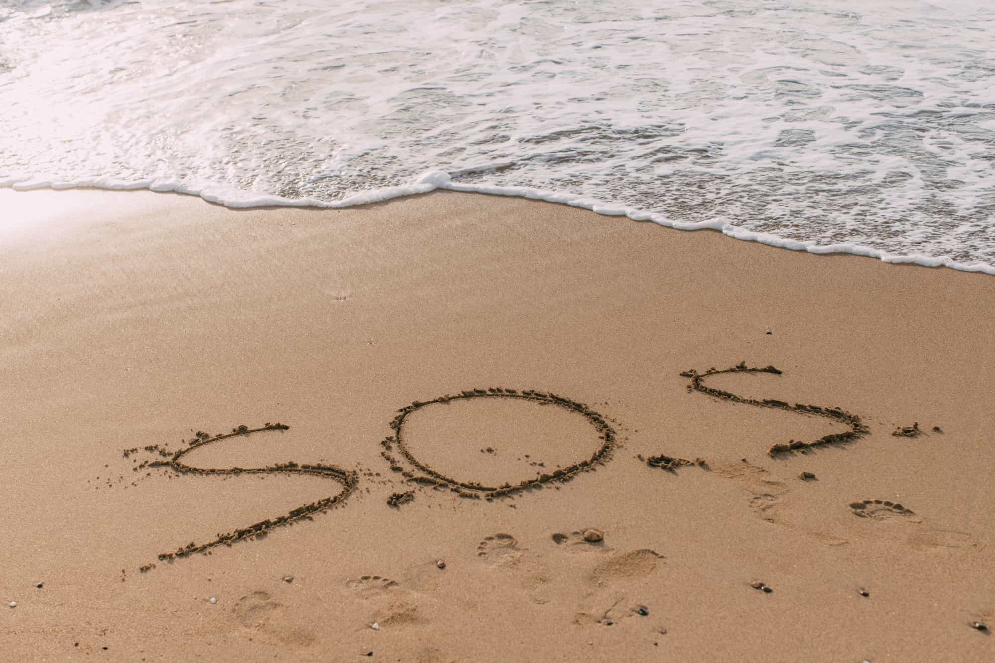 SOS written in the sand.